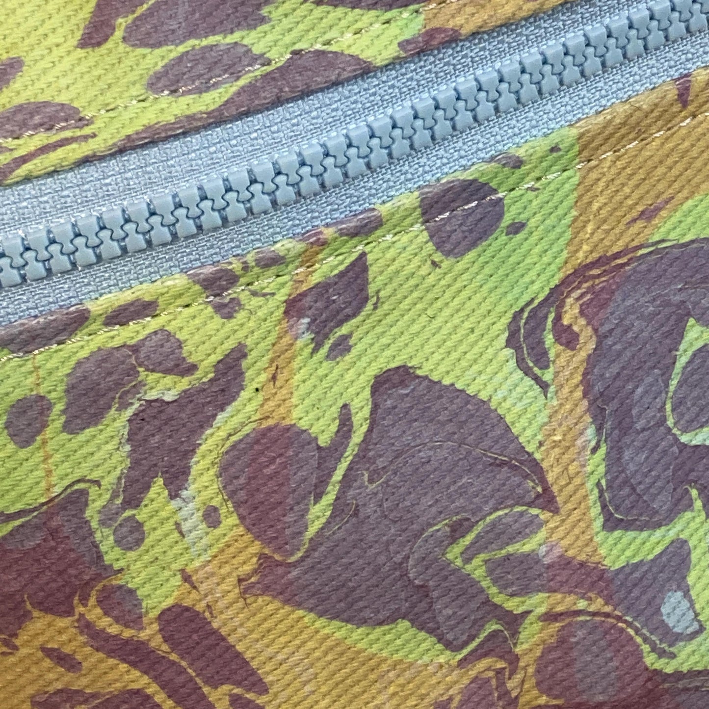 Close up of zipper on a water mabrled fanny pack