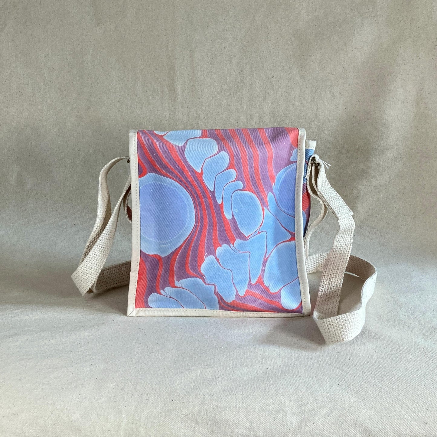 A mini square water marbled messenger bag with a flap