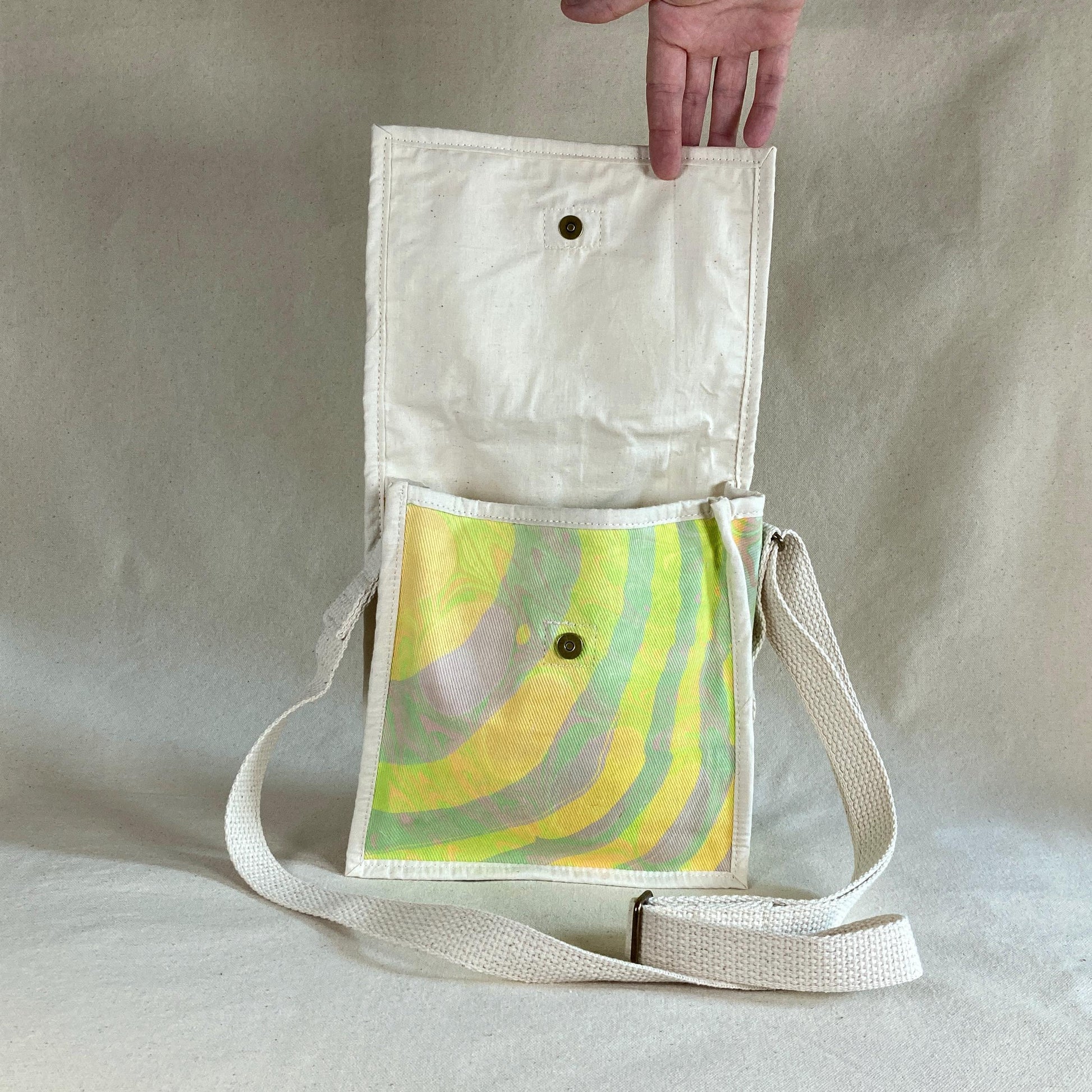 Water marbled miniature messenger bag with flap opened to show magnetic closure